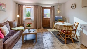 Ein gemütliches Wohnzimmer mit einer Couch, einem Couchtisch und einem Essbereich mit Tisch und Stühlen.