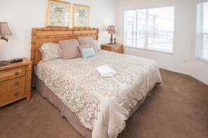 A bedroom with a large bed, a wooden headboard, two bedside tables with lamps, and a window with blinds. - Ip60344 - Windsor Hills Resort - 5 Bed 5 Baths Villa (Kissimmee)