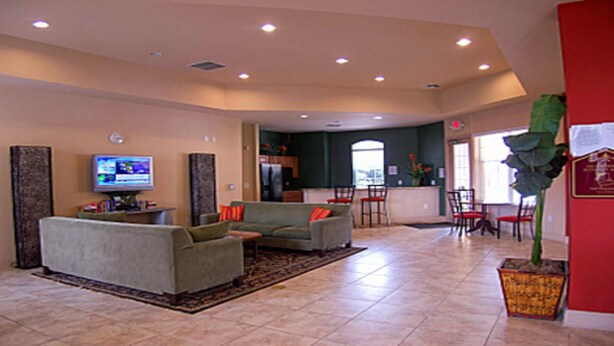A spacious living room with a sofa, a television, and a dining area with chairs and a table. - Tr422 - Terrace Ridge - 2 Bed 2 Baths Condo (Davenport)