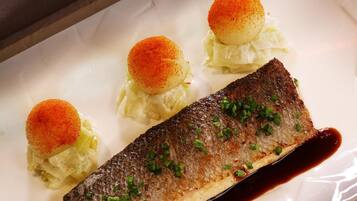 A dish with a fish, cabbage, and a sauce.