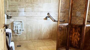 A bathroom with a shower, a towel rack, and a toilet.