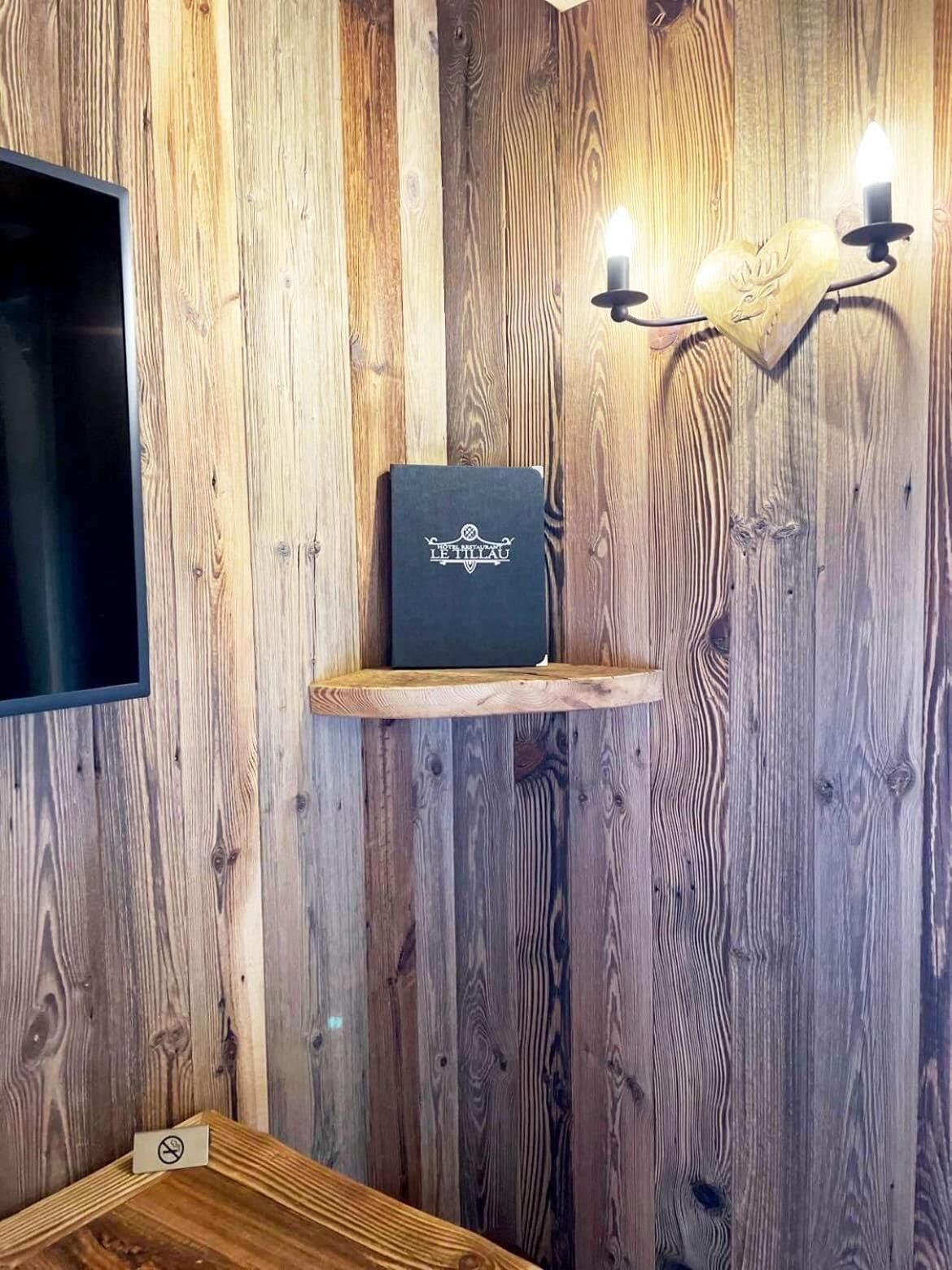 Eine Holzwand mit einem Regal, auf dem ein Buch mit dem Titel 