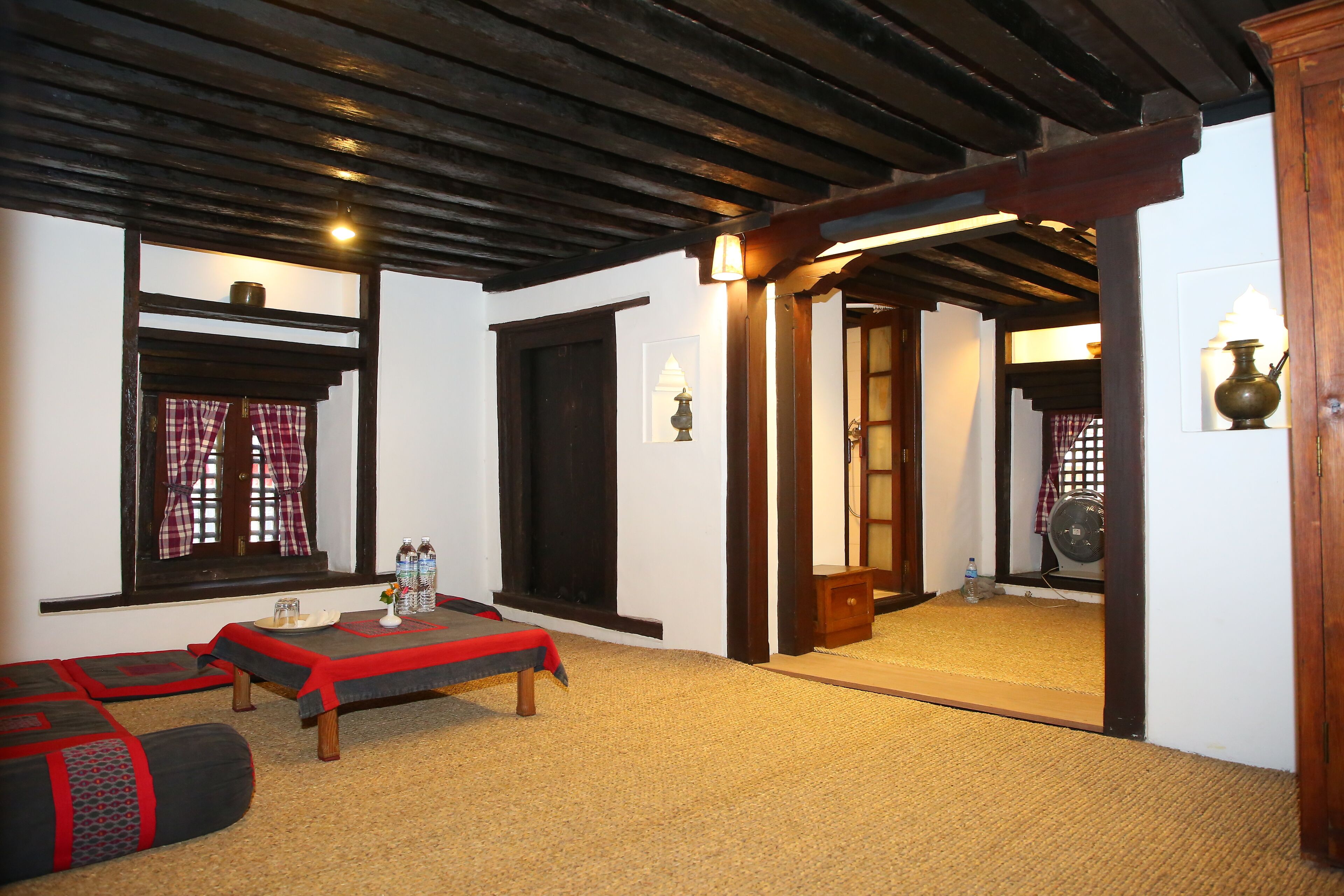 A traditional room with tatami mats, a low wooden table, and a sliding door leading to another room.