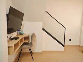 A modern room with a desk, chair, and a large flat-screen TV.