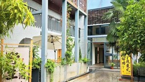 A modern building with a covered outdoor area, featuring a tiled floor and potted plants. - First Sight Hotel,Next to Yingtianmen Imperial City,Provide Airport and High-Speed Rail Station Pickup (Luoyang)