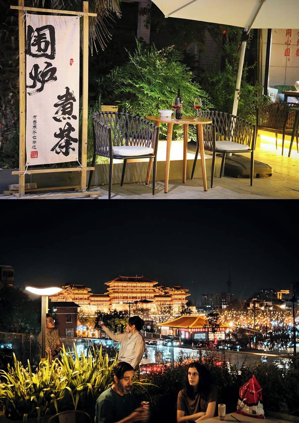 Un espacio para comer al aire libre con mesas y sillas, un cartel con caracteres chinos y vistas de un edificio tradicional por la noche.