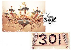 A chandelier with multiple candle-like lights and a logo with a deer and trees.