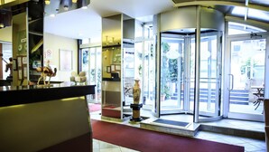 A hotel lobby with a revolving door, a reception desk, and a decorative vase. - Anka Premium Hotel (Istanbul)
