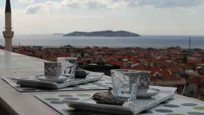 A table with a view of a coastal city, a mosque, and a distant island. - Anka Premium Hotel (Istanbul)