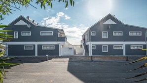 A residential building with a symmetrical design, featuring two-story structures with a central entrance. - Fork West Apartments - Top Floor 5 (Cederberg)