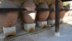 Terracotta pots arranged in a row on a stone wall, supported by a metal frame. - Hotel Rural Luna Llena (Torremocha de Jarama)