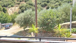 A balcony with a view of a hilly landscape, a table with a potted aloe plant, and a bowl of colorful clothespins. - Maisonette Maria - for tranquility. Sykia Chalkidikis (Sithonia)