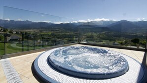 Un jacuzzi con vistas panorámicas a la montaña desde un balcón.