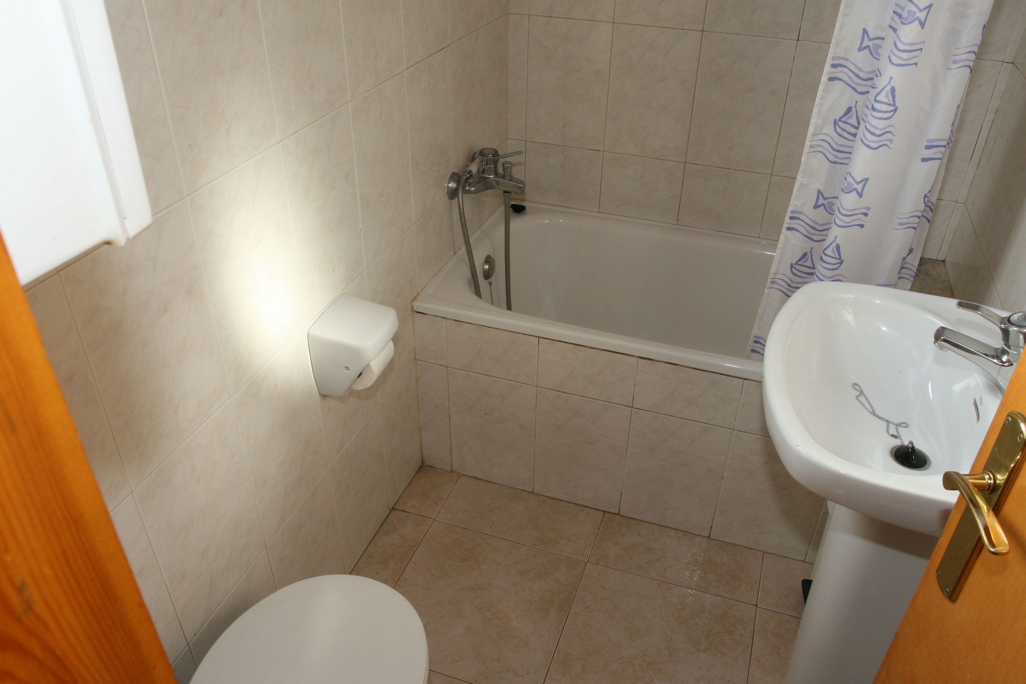 A bathroom with a toilet, a sink, and a bathtub.