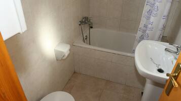 A bathroom with a toilet, a sink, and a bathtub.
