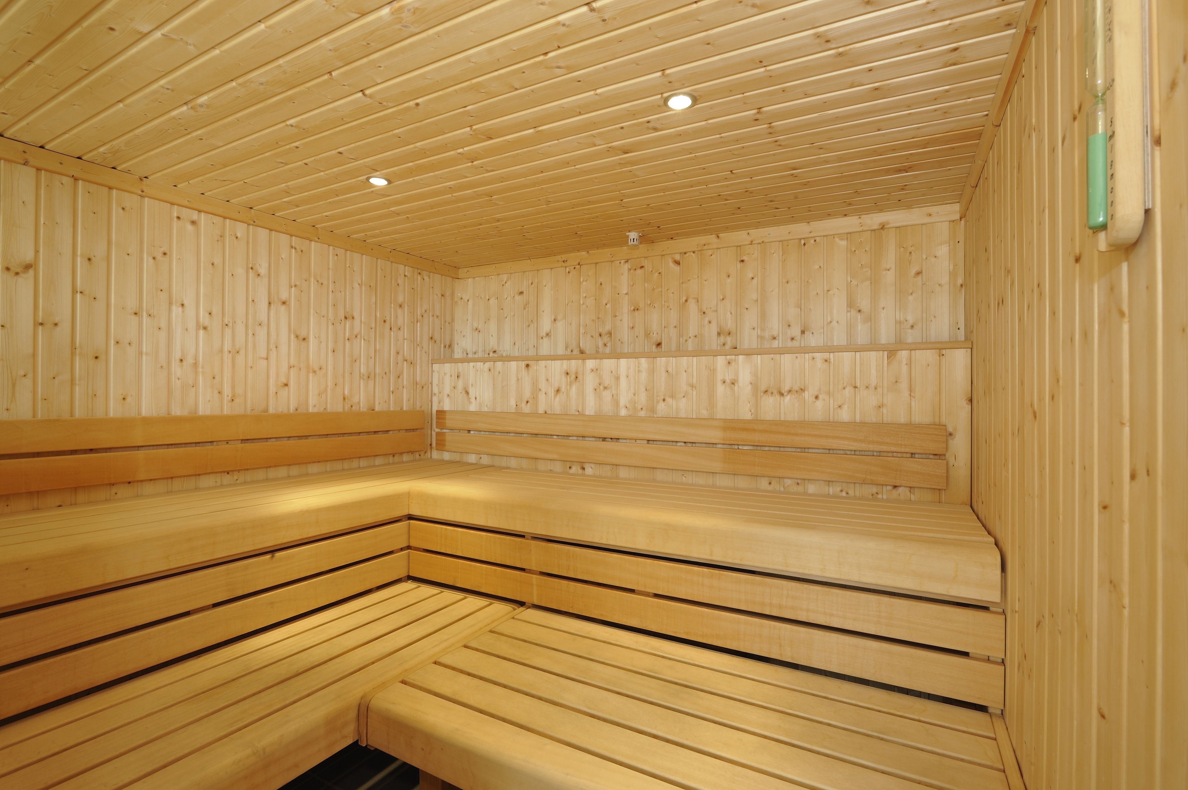 Un sauna avec des bancs en bois et un plafond incliné.