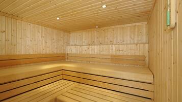 Un sauna avec des bancs en bois et un plafond incliné.
