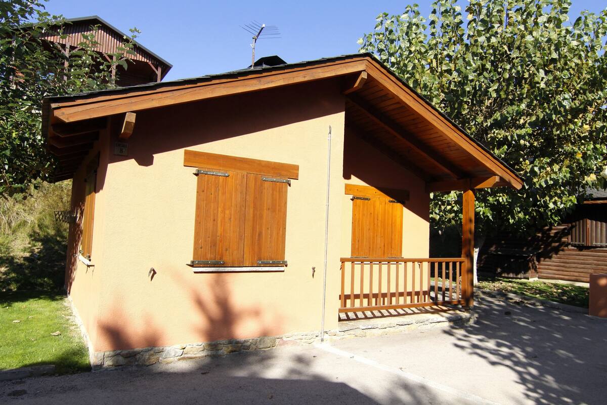 A small, single-story building with a wooden balcony and a door.