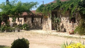 A rustic stone building with a garden in front. - Gite La Raymondiere (Vernoux-en-Gatine)