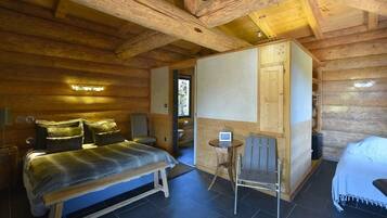 Une chambre à coucher de style rustique, avec un lit, une chaise et une petite table.