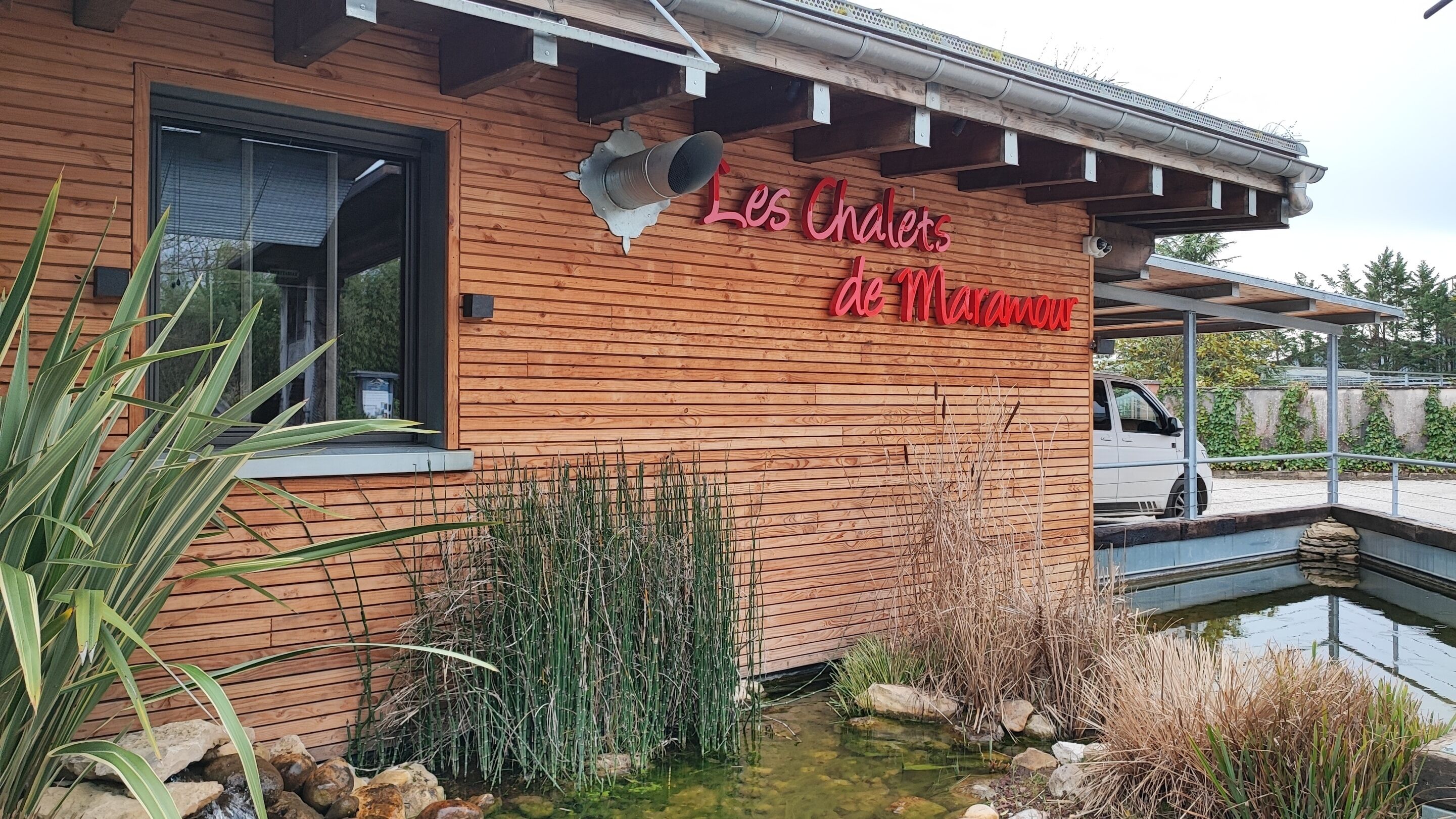 Un edificio de madera con un letrero que dice "Les Chalets de Maranou".