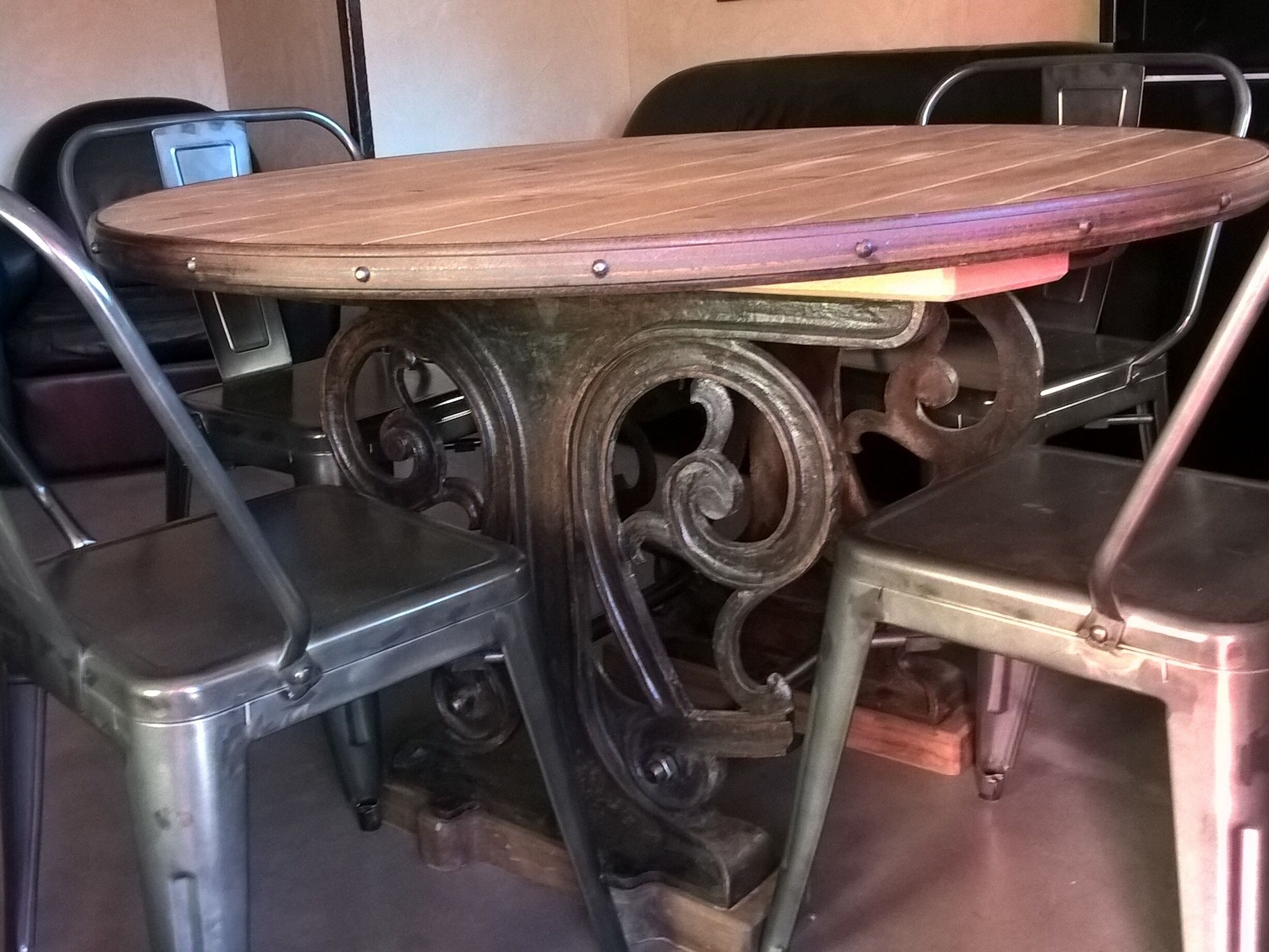 A round table with a wooden top and metal base, surrounded by metal chairs.