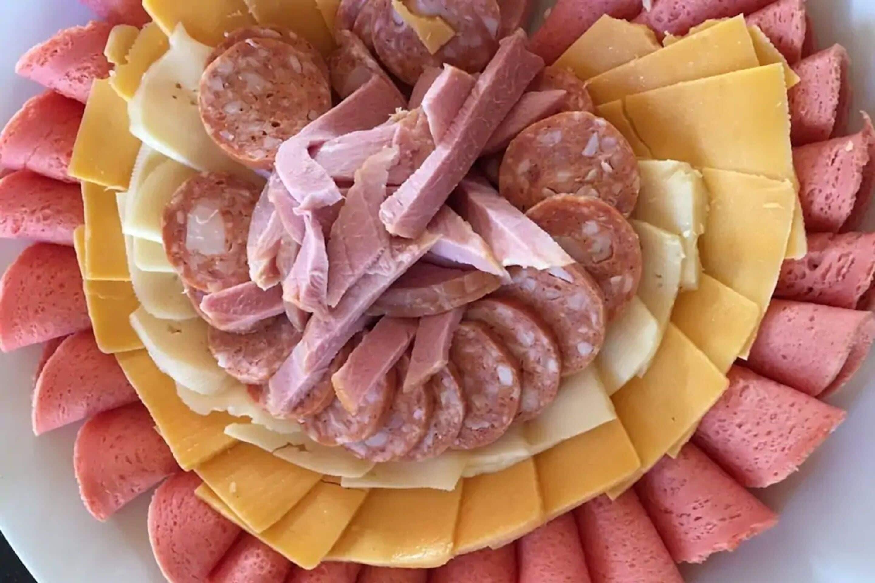 A platter of sliced meats and cheeses arranged in a circular pattern.