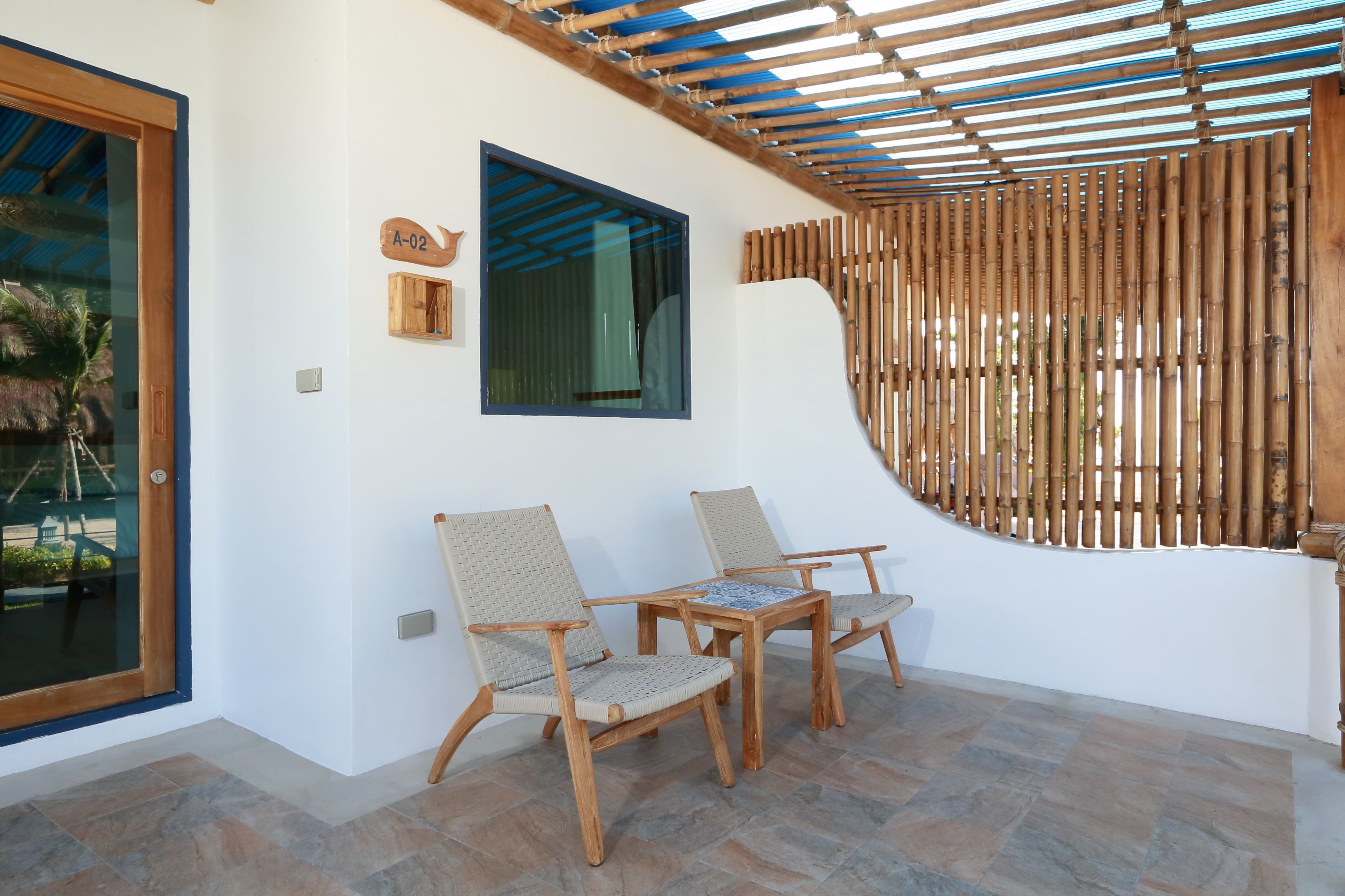 A room with a wooden table and chairs, a large window, and a bamboo screen.