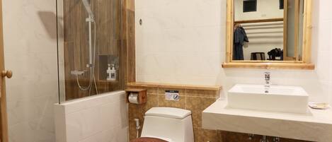 A bathroom with a glass-enclosed shower, a toilet, a sink, and a mirror.