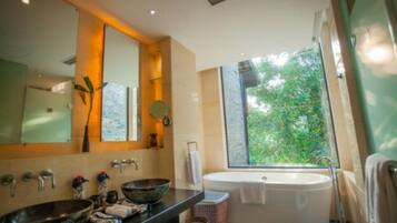 Un baño moderno con una bañera grande, dos lavamanos y un espejo amplio.