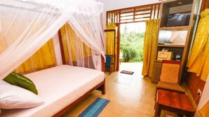 A room with a bed, a television, and a desk with a chair. - Yoho Milkyway Holiday Resort (Unawatuna)