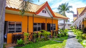 A resort with a thatched roof, a covered outdoor seating area, and a paved walkway. - Baan Kasirin Resort Pattaya Beach (Koh Lipe)