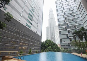 A modern building with a swimming pool surrounded by high-rise buildings.
