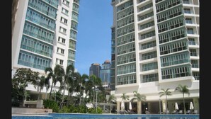A modern hotel with a pool, palm trees, and high-rise buildings in the background. - Marc B20-09 by SYNC (Kuala Lumpur)