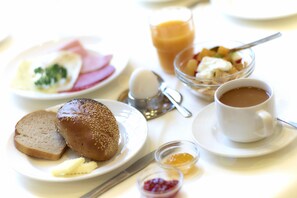 A breakfast setting with bread, eggs, ham, fruit, and coffee. - Ebernburg (Bad Kreuznach)