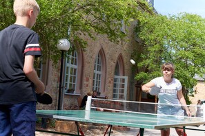 A table tennis game in an outdoor setting with a stone building in the background. - Ebernburg (Bad Kreuznach)