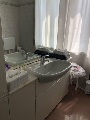 A modern bathroom with two sinks, a mirror, and a towel rack. - Dimora Del Podestà (Castell'Arquato)