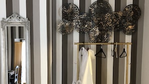 A room with a bed, a mirror, and a clothing rack with hangers. - Dimora Del Podestà (Castell'Arquato)
