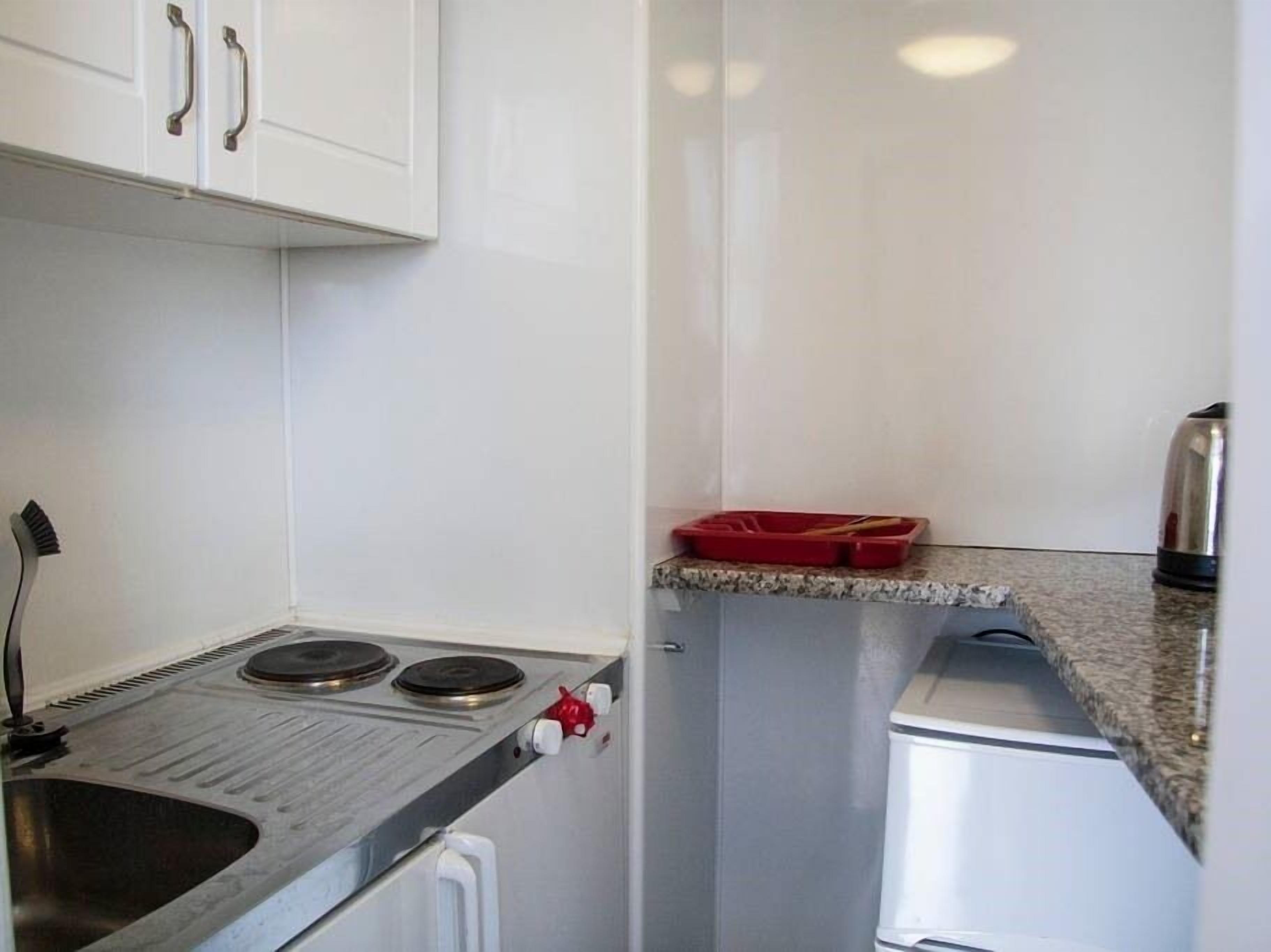 A compact kitchen with a gas stove, a sink, and a small countertop.