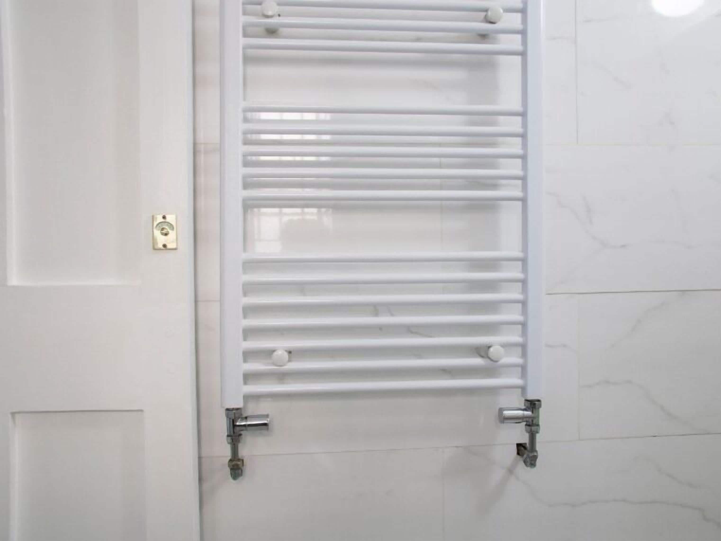 A white towel rack with multiple horizontal bars and two metal brackets at the bottom.