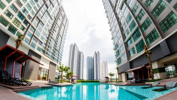 Uima-allas, jonka ympärillä kohoavat korkeat rakennukset, ja jonka yhteydessä on aurinkotuoleja ja palmuja.