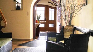 Vestíbulo de hotel con mostrador de recepción, una escalera y una puerta con la leyenda 'Cherrytree'.