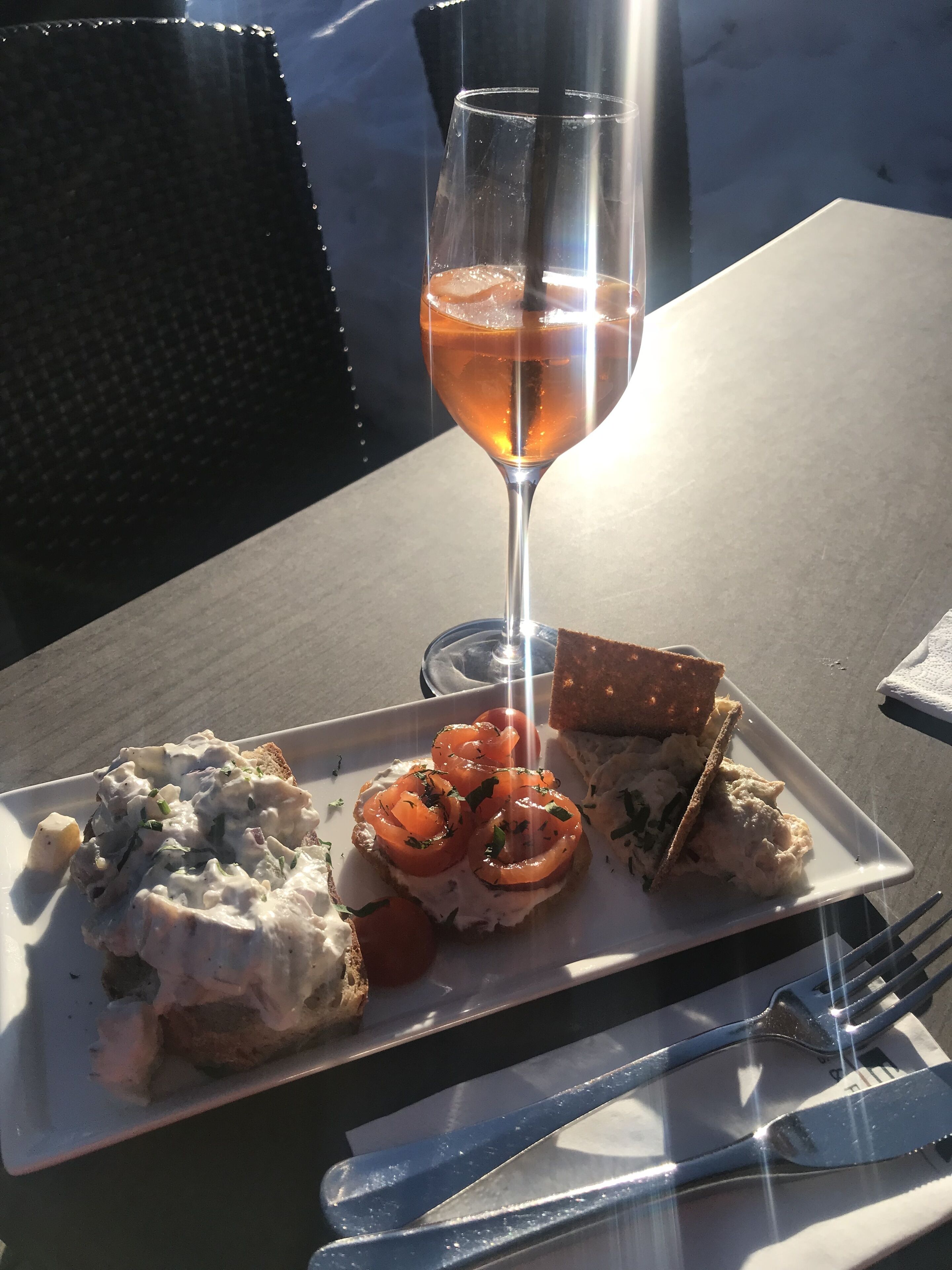 A plate of food with a glass of drink on a table.