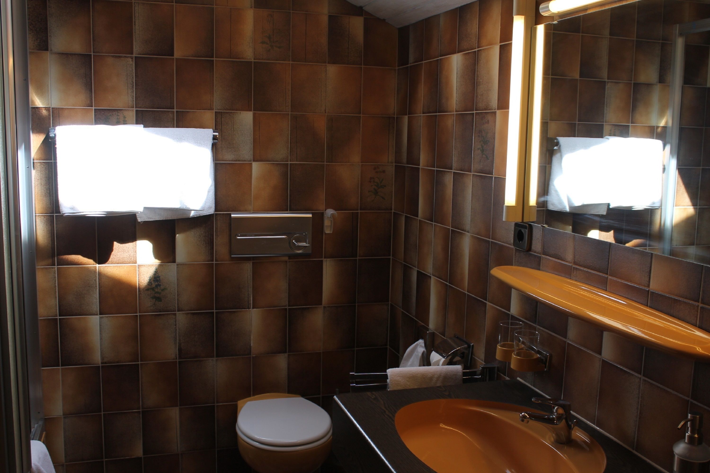 Un baño con inodoro, lavabo y espejo.