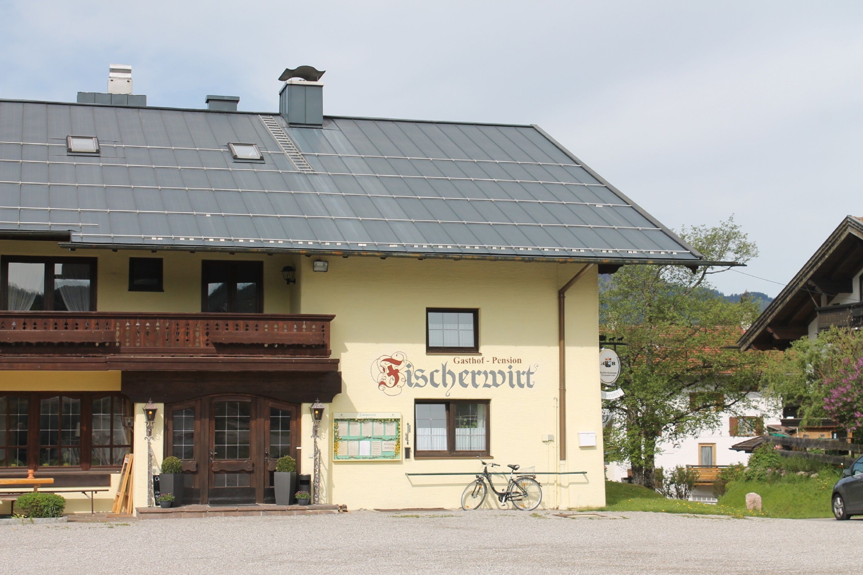 Un edificio con un letrero que dice 'Gasthof - Pension Fischerwirt'.