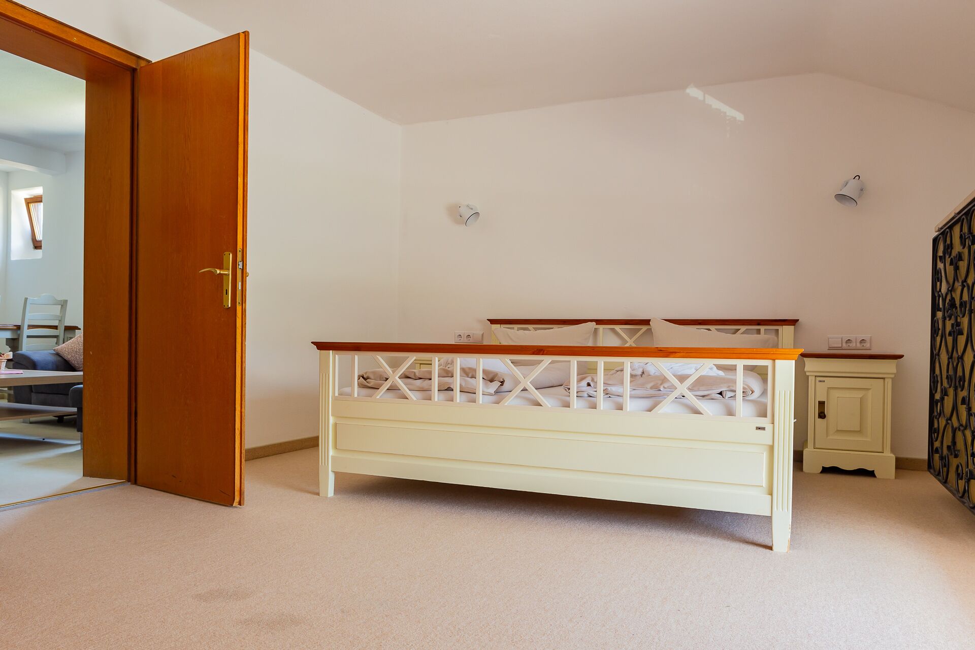 Ein Schlafzimmer mit einem Einzelbett, einer Holztür, einem kleinen Schrank und einer Heizung.