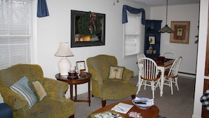 A living room with patterned armchairs, a dining table with chairs, a lamp, and a framed picture on the wall. - Great Mountain Get Away (Boone)