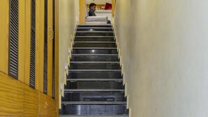 En trappa med träpanel på vänster sida och en enkel vägg på höger sida.