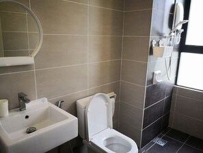 A bathroom with a white sink, toilet, and shower.