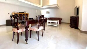 A spacious living area with a dining table and chairs, a sofa, and a television. - Santa Lucia B&B (Gaeta)